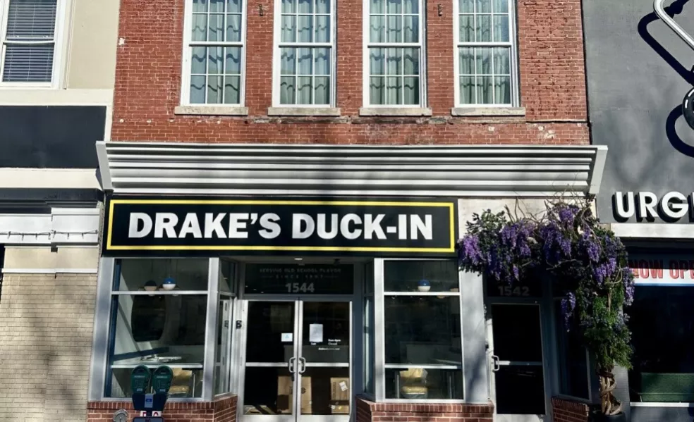Storefront that says "Drake's Duck-In" with four windows on brick facade above.